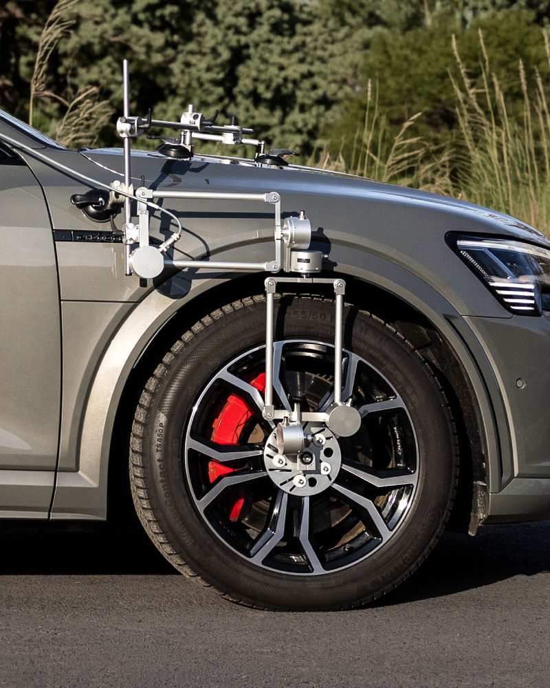 WVS Wheel Vector System by Sensoric Solutions mounted on a test vehicle wheel, showing hub adapter and parallelogram mechanism